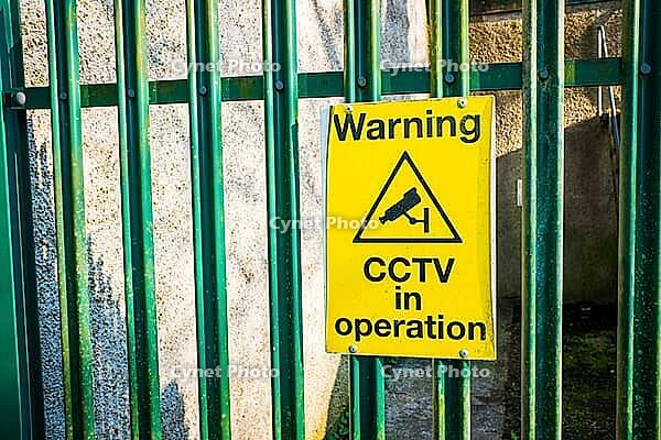Close up photo of warning sign board on green fence [IBR125331169]