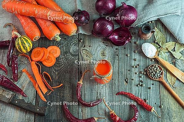 Fresh vegetables and a glass of carrot juice on an old wooden surface, top view [IBR125331198]