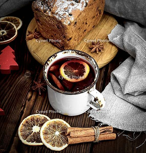 Mulled wine in a white iron mug and baked pie with dried fruits, top view [IBR125331209]