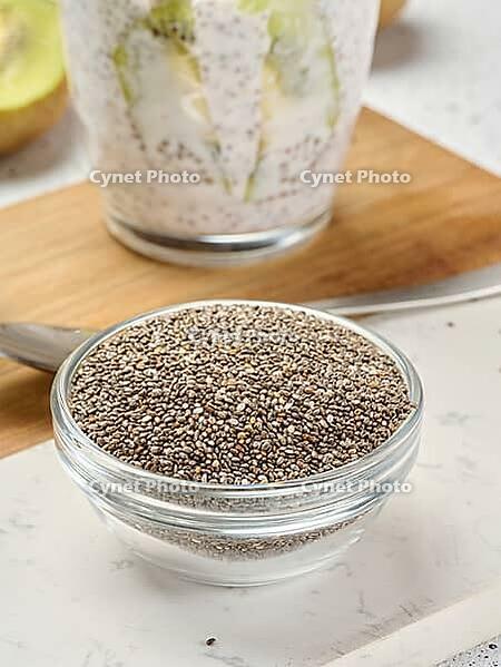 Clear glass bowl filled with dry chia seeds, top view [IBR125344260]