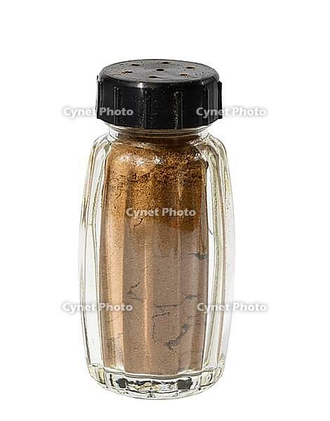 Transparent glass jar with ground cinnamon on a white isolated background, spice [IBR125344288]