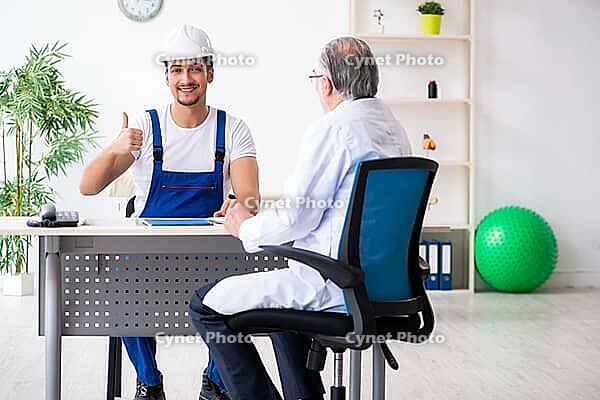 Young male contractor visits old doctor [IBR125344321]