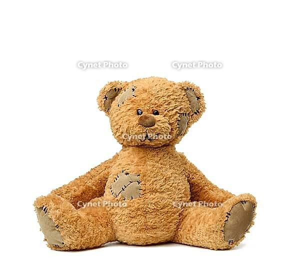 Brown teddy bear sits on a white background, toy with patches [IBR125344323]