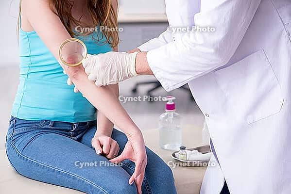 Young arm-injured woman visits young doctor traumatologist [IBR125344325]