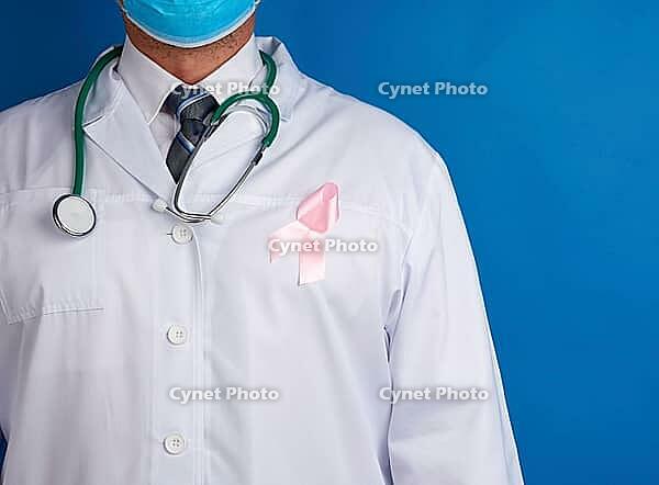 Pink silk ribbon attached to a white medic coat, symbol of the fight against breast cancer in October [IBR125363549]