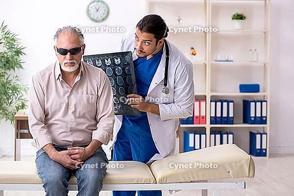 Old man visits young male doctor [IBR125382573]