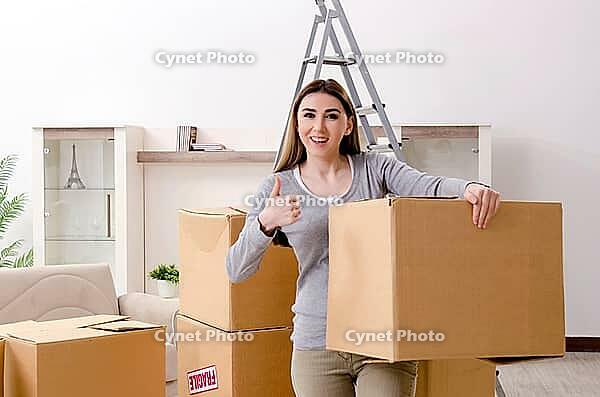 Young beautiful woman moves into a new apartment [IBR125382587]