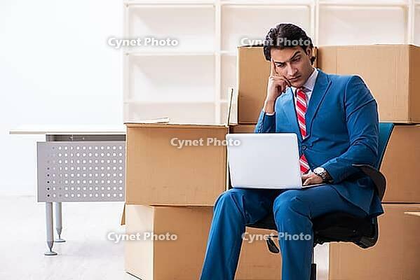 Young handsome businessman moves to a new job [IBR125382589]