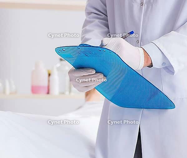 Police coroner examines body in morgue [IBR125382607]