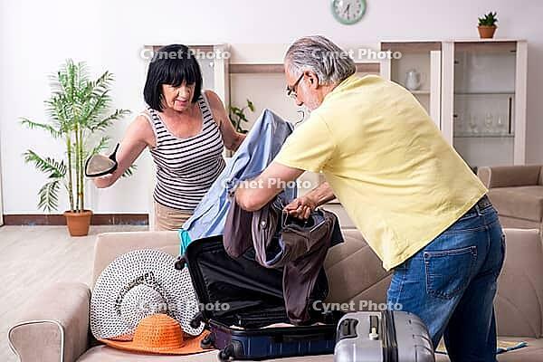 The old couple is preparing for vacation trips [IBR125382615]