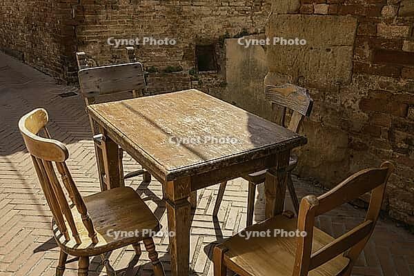A Vintage Table And Four Chairs On A Street In Ancient Certaldo, Tuscany [IBR125382626]