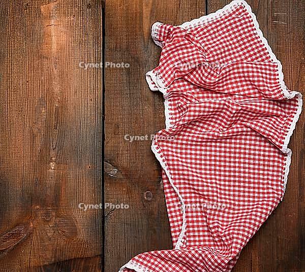 Red kitchen towel on brown wooden background, top view, copy space [IBR125382630]