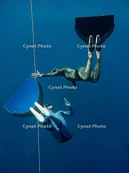 One freediver stops his movement while other controls friend's behaviour [IBR125382633]