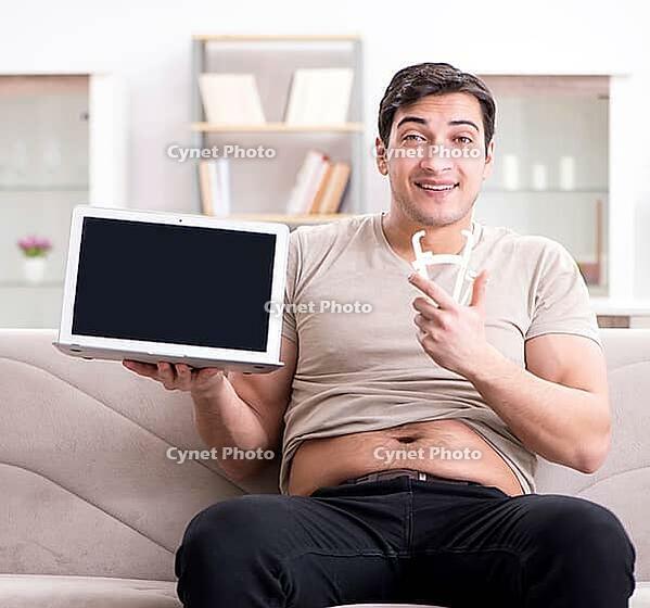 The man measures body fat with calipers [IBR125382634]