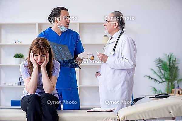 The two doctors examine young woman [IBR125382643]