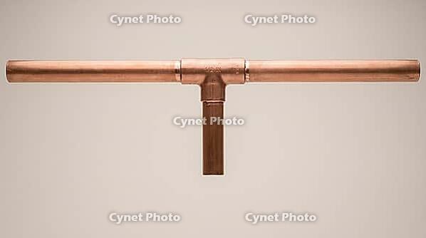 A copper pipe T-junction with a short branch line, smooth even exterior surface on all fittings, no visible marks, on a plain grey studio background, close-up product shot, AI generated [IBR125395940]