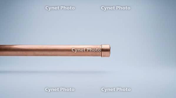 A capped copper pipe section with a smooth metal end cap and even exterior surface, no visible marks or moisture, on a plain grey studio background, close-up product shot, AI generated [IBR125395944]