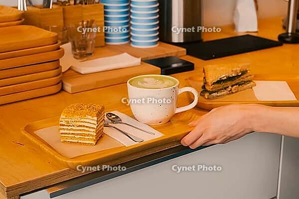 A mug of coffee with a piece of cake on a tray. Morning breakfast at the cafe [IBR125405031]