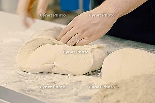 Rolling out the dough with your hands, flour and white dough [IBR125405044]