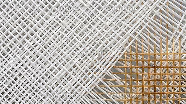 Extreme close-up of a cross-hatched white synthetic tennis racket string bed with one section of natural gut strings visible, full frame texture, even studio lighting, sports equipment, AI generated [IBR125407408]