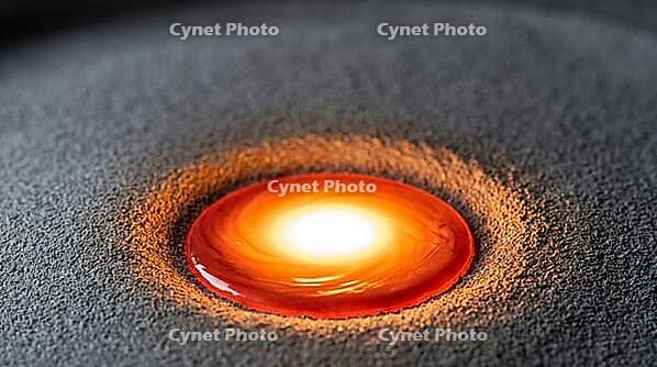 Close-up of a brilliant white-hot molten titanium weld pool with orange and red edges on a bed of fine grey titanium powder, active laser fusion moment, industrial macro photography, AI generated [IBR125407416]