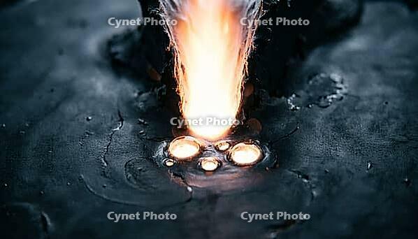 Abstract cross-section visualization of a glowing keyhole vapor depression cavity with trapped porosity voids in molten metal, dark background, additive manufacturing defect science, AI generated [IBR125407423]