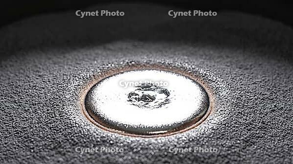 Close-up of a brilliant silver-white molten aluminum weld pool on a bed of fine matte grey aluminum powder, instant of fusion, industrial macro photography, additive manufacturing, AI generated [IBR125407468]