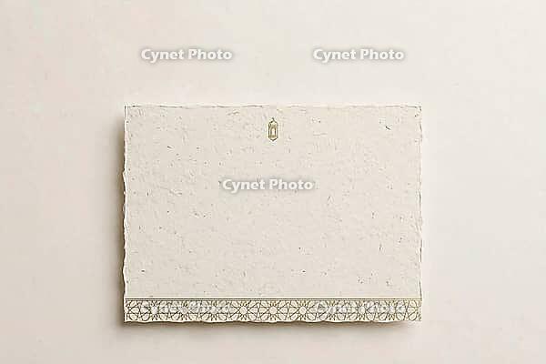Traditional ornate hanging lantern casting a beautiful Islamic geometric shadow on a textured beige wall, AI generated [IBR125407478]