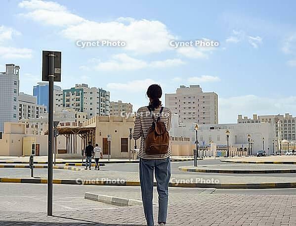 Female tourist with backpack on Arab roads in the old town of Sharjah, United Arab Emirates [IBR125411069]