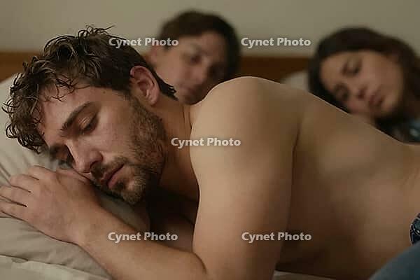 Shirtless young man sleeping peacefully on a pillow in bed beside companions, intimate morning rest, shared domestic vulnerabilities in cozy bedroom, tranquil somatic regeneration of exhausted youth after long night, blurred background figures resting tog [IBR125414164]