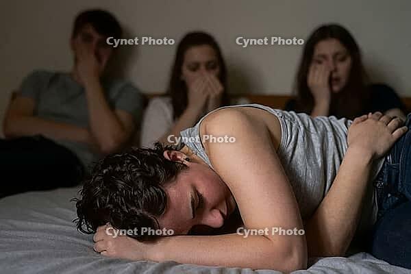 Mental health crisis, emotional trauma, depression, grief among youth, young adult crying on bed while friends react in shock and disbelief, overwhelming psychological distress within a close group of peers, somber atmosphere of vulnerability and sudden l [IBR125414179]