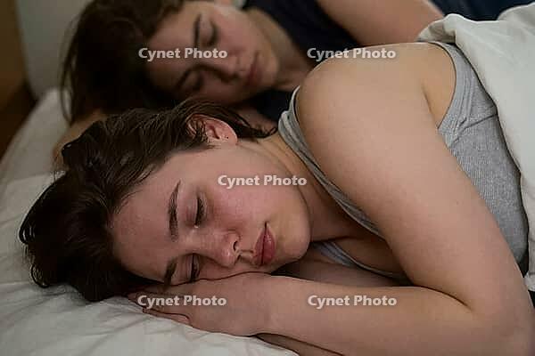 Deep restorative sleep of two young women in bed, somatic recovery through peaceful intimacy and neurological rest during circadian regeneration phases, closed eyes showing vulnerability and interpersonal trust in private domestic space, relaxed facial ex [IBR125414186]