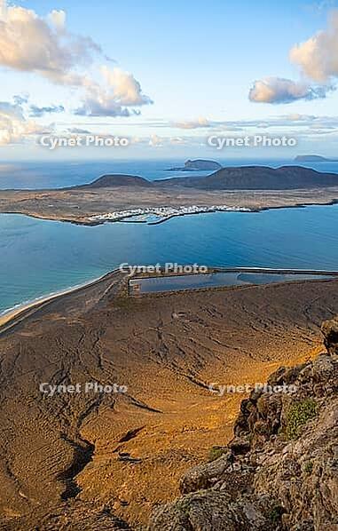 View of steep cliffs to sea and the island of La Graciosa, Mirador del Porrito viewpoint at sunset, Lanzarote, Canary Islands, Spain [IBR125414243]