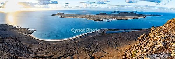 View of steep cliffs to sea and the island of La Graciosa, Mirador del Porrito viewpoint at sunset, Lanzarote, Canary Islands, Spain [IBR125414247]