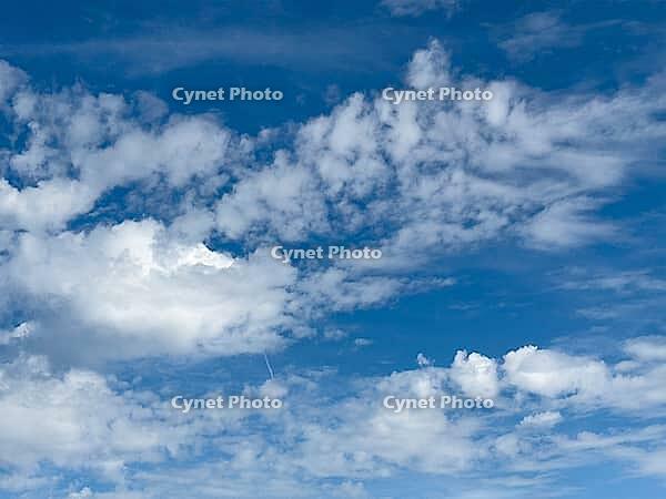 Wind-driven white cluster clouds Cumulus above floating Alttocumulus Cumulus under blue sky, Germany [IBR125414258]