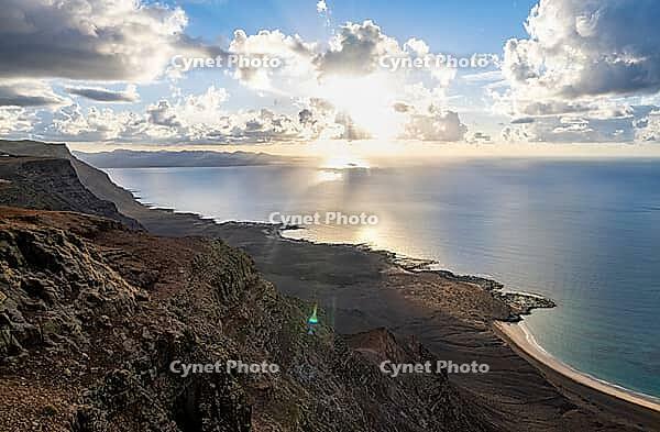 Steep cliffs on the coast with sea, Mirador del Porrito viewpoint at sunset, Lanzarote, Canary Islands, Spain [IBR125414262]