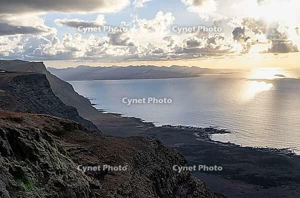 Steep cliffs on the coast with sea, Mirador del Porrito viewpoint at sunset, Lanzarote, Canary Islands, Spain [IBR125414263]