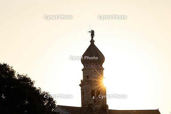 Sunrise behind the bell tower of the Assumption Cathedral with baroque onion dome and trumpet blowing angel, old town of Krk, island of Krk, Croatia [IBR125415379]