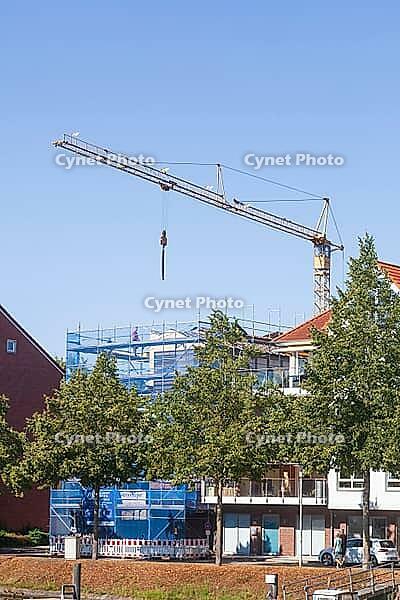 Shell of a residential building with scaffolding, construction crane and blue safety net, residential construction, Emden, East Frisia, Lower Saxony, Germany [IBR125415400]