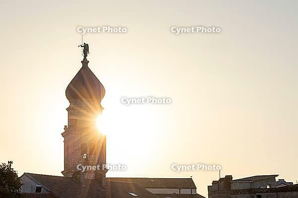 Sunrise behind the bell tower of the Assumption Cathedral with baroque onion dome and trumpet blowing angel, old town of Krk, island of Krk, Croatia [IBR125415404]