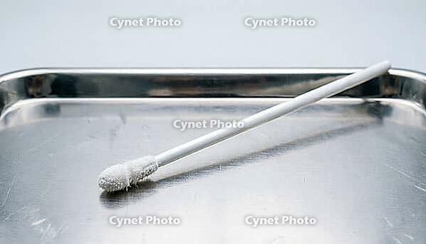 Close-up of a single unused white fiber trace sample collection swab on a stainless steel tray, clinical studio lighting, forensic sample collection photography, AI generated [IBR125421247]