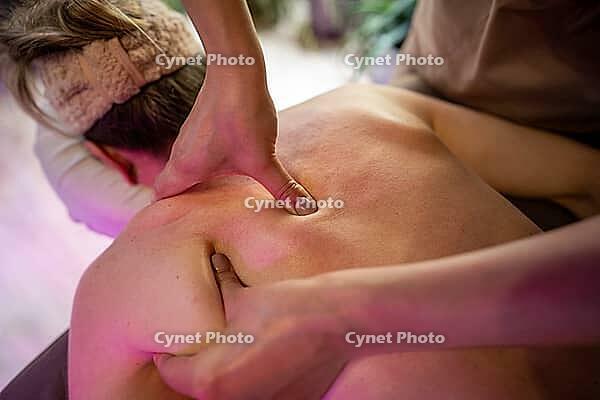 Woman client receiving healing full body massage in spa salon, lady attending manual therapy session, masseuse performing treatment procedure for removing back muscle blocks, pain relief and wellbeing [IBR125421615]
