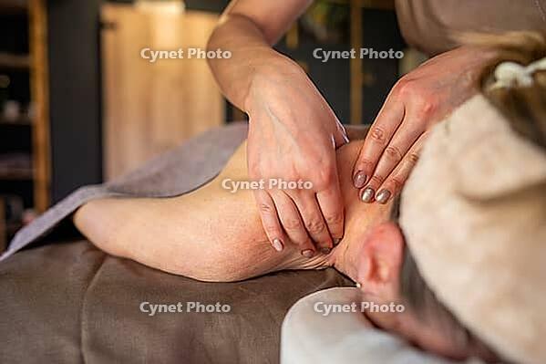 Lady masseuse in spa center making therapeutic lymphatic drainage massage on neck and shoulder for woman lying on couch half naked. Female enjoying body care. Physiotherapy and relaxation treatment [IBR125421639]