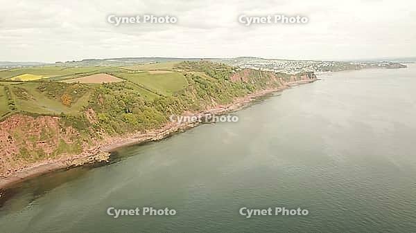 Panoramic view of cliffs and water with rolling fields stretching into the distance, - Drone photography - South coast of Devon, England, UK [IBR125421670]