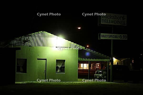 A lone cheap motel, with a neon green glow at night, featuring a diner sign and a parked car, Salton Sea, California, USA [IBR125421671]