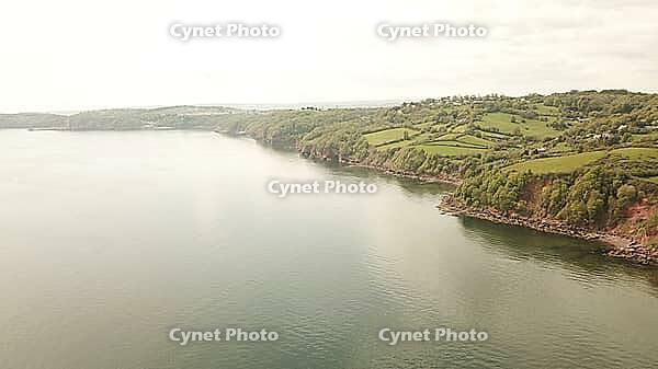 Tranquil coastal scene viewed from above, with calm waters and lush greenery, - Drone photography - South coast of Devon, England, UK [IBR125421678]