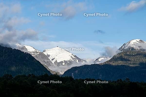 Glaciated impressive mountain peak, mountains with forest, Carretera Austral, near Villa Santa Lucia, Los Lagos, Chile [IBR125423469]