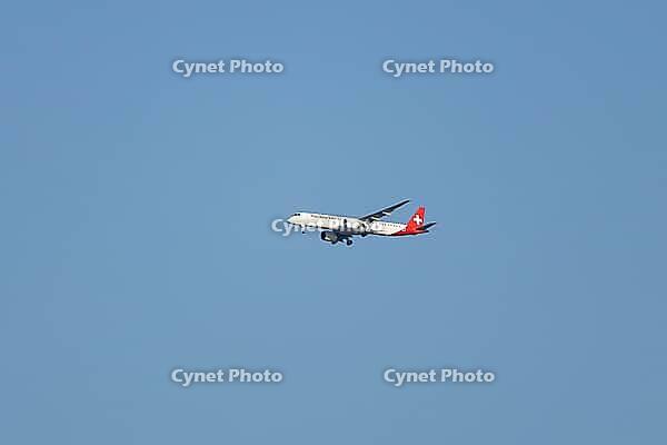 Embraer 195-E2 jet commercial passenger aircraft of Helvetic Airways airline flying in a blue sky on approach to land at London city airport, England, United Kingdom [IBR125423472]