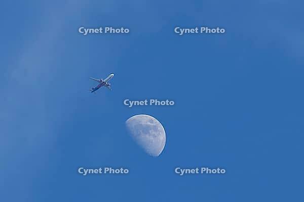 Airbus jet commercial passenger aircraft of Wizzair airlines flying in a blue sky with the moon in the background, England, United Kingdom [IBR125423479]