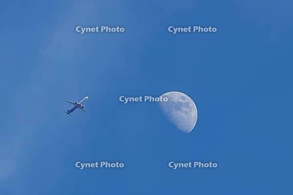 Airbus jet commercial passenger aircraft of Wizzair airlines flying in a blue sky with the moon in the background, England, United Kingdom [IBR125423487]